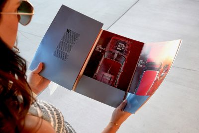 Person reading a full-colour brochure showcasing automotive graphics, an example of brochure printing in Calgary for professional marketing materials.