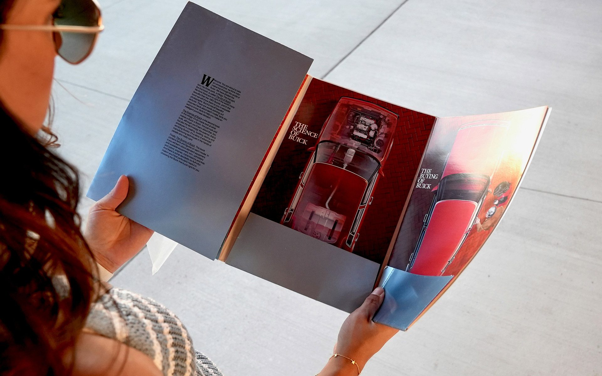 Person reading a full-colour brochure showcasing automotive graphics, an example of brochure printing in Calgary for professional marketing materials.