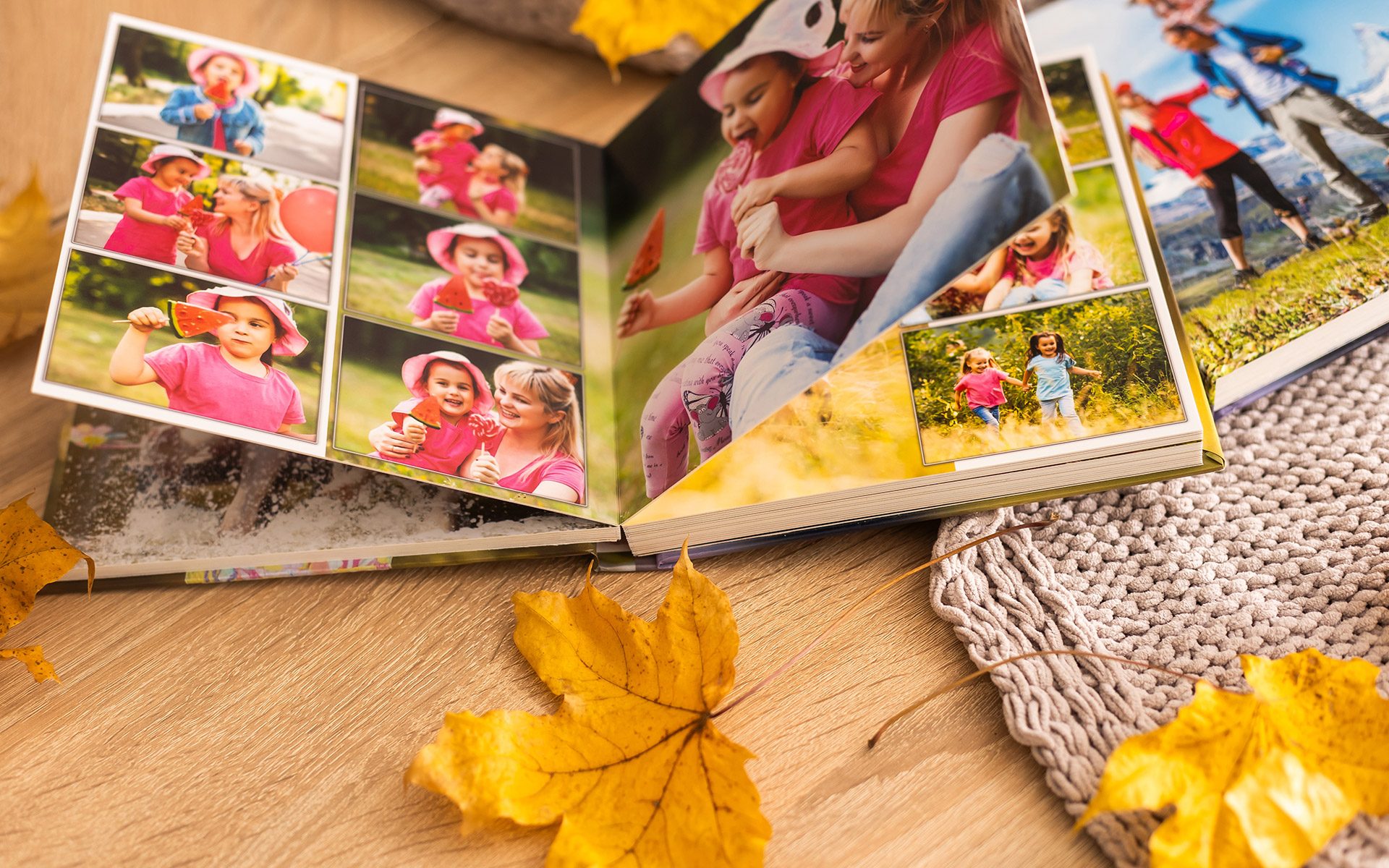 Colorful photo book on a wooden table with autumn leaves, showcasing seasonal printing in Calgary.